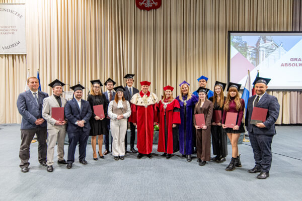 grupa osób na scenie, z tyłu prezentacja